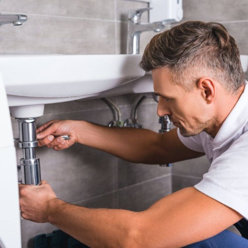 adult-plumber-fixing-sink-at-bathroom
